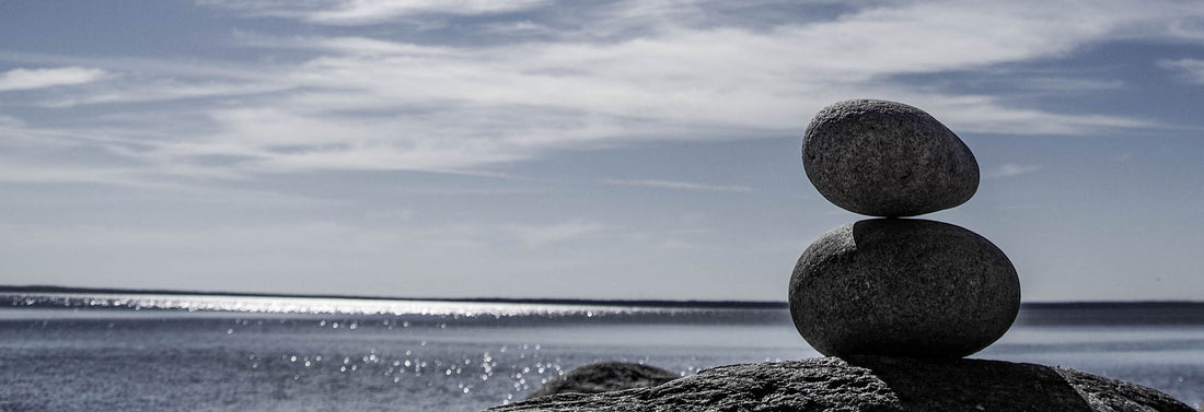 Balanced stone tower on the beach with calm ocean in the background